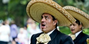 man s black blazer and brown traditional hat